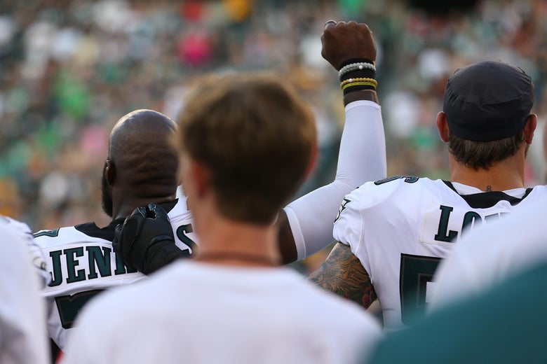 Malcolm Jenkins #27 of the Philadelphia Eagles raises his fist during the national anthem as Chris Long #56 puts his arm around him